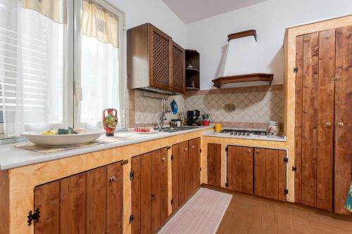 a kitchen with wooden cabinets and a sink at Casa splendida in Monreale