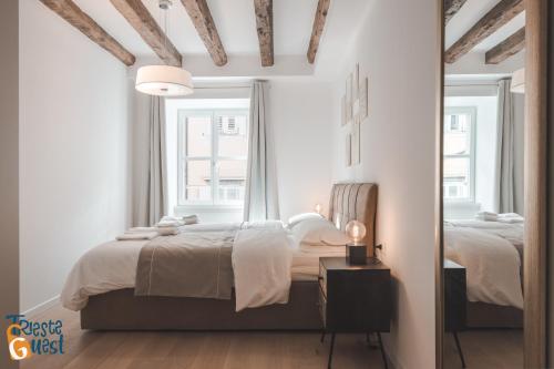 um quarto branco com 2 camas e uma janela em Michael&Renate - Stylish studio em Trieste