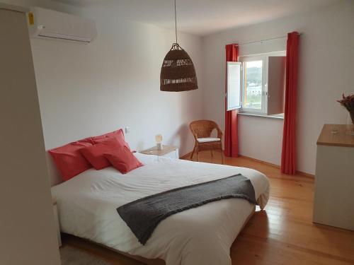 - une chambre avec un lit et des oreillers rouges dans l'établissement Casa do Ferrador - Mação, à Mação