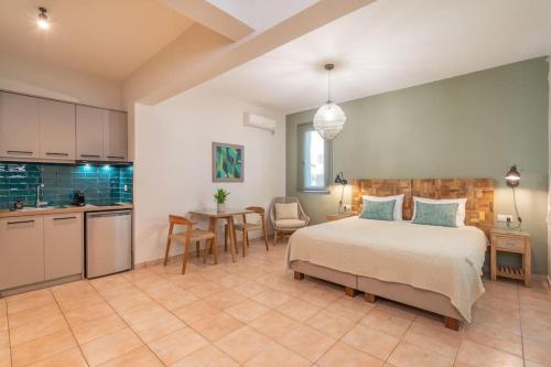 a bedroom with a bed and a table and a kitchen at Seashell Luxury Residence - Studio 1 in Lixouri