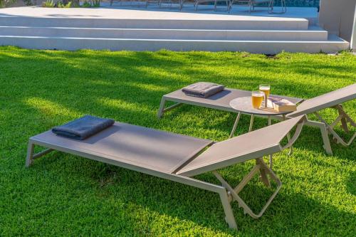 a picnic table and a bench in the grass at Seashell Luxury Residence - Studio 1 in Lixouri