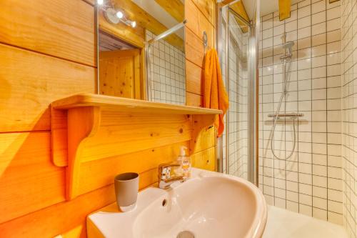 uma casa de banho com um lavatório e um espelho em Alpes Sweet Home - Chalet en 7 em Alpe-d'Huez