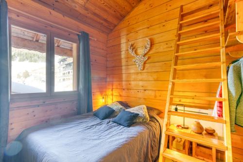 um quarto com uma cama num chalé de madeira em Alpes Sweet Home - Chalet en 7 em Alpe-d'Huez