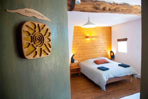una camera con un letto e un cartello a muro di Les Soleils a Mérinchal