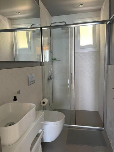 a bathroom with a shower and a toilet and a sink at By The Sea - Paleros in Paleros