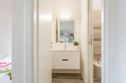 a white bathroom with a sink and a mirror at AfforiCentro in Milan