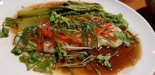 a white plate of food with broccoli and other vegetables at Stargate Villa Pintu Bintang in Pawenang