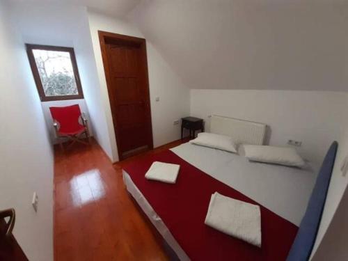 een slaapkamer met een groot bed in een kamer met een rode deken bij CRYSTAL CLEAR AIR, TRANQUILITY & STUNNING SUNSETS in Vlăhiţa