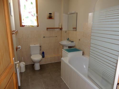 een badkamer met een toilet, een wastafel en een bad bij Chestnut cottage (Les Gîtes Champêtres) in Sainteny