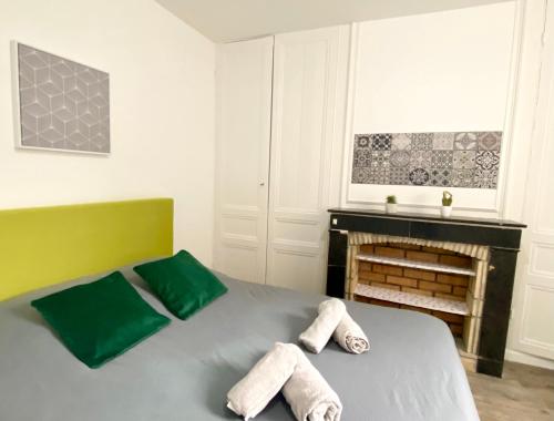 ein Schlafzimmer mit einem Bett mit zwei Handtüchern darauf in der Unterkunft * Le Droma D’or * Appartement Confort * Centre-ville in Calais
