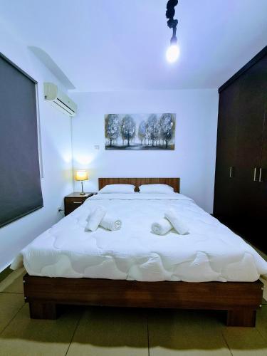 1 dormitorio con 1 cama grande con sábanas blancas en Ayia Anna Apartment, en Ayia Napa