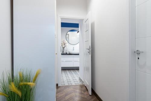 a white bathroom with a sink and a mirror at Cozy apartment in the center of Krakow in Krakow