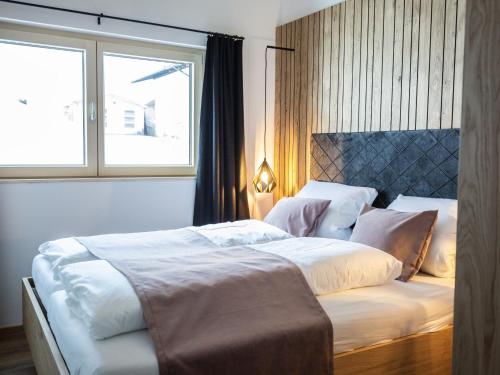 1 dormitorio con 2 camas y ventana en Kracha Alpinlodge en Mittelberg