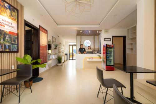 a kitchen and dining room with a man in the background at The Cuckoo's Nest Hostel and Bar managed by Hoianese in Hoi An
