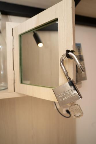 a padlock is attached to a cabinet with a window at The Cuckoo's Nest Hostel and Bar managed by Hoianese in Hoi An