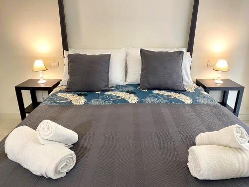 a bedroom with a large bed with towels on it at Front Beach Deluxe Apartment - with access to beach club in Viareggio