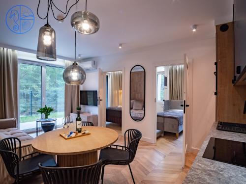 een woonkamer met een tafel en stoelen en een slaapkamer bij Apartament na wydmie - Porto Łeba in Łeba