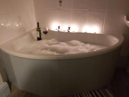 a white bath tub with a bottle of wine in it at Poppy's Place Annex in Camelford North Cornwall in Camelford