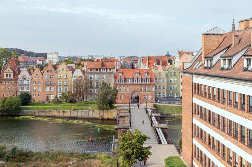 uitzicht op een stad met een rivier en gebouwen bij Grano Green Comfort Residence by Renters Prestige in Gdańsk