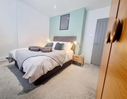 a bedroom with a large bed with a blue wall at West Cliff Apartment in Bournemouth