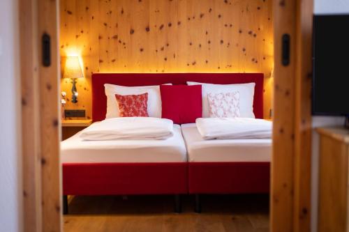 a red and white bed in a room at Hapimag Ferienwohnungen Zell am See in Zell am See