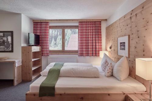 a bedroom with a large bed and a window at Bio Hotel Stillebach in Sankt Leonhard im Pitztal