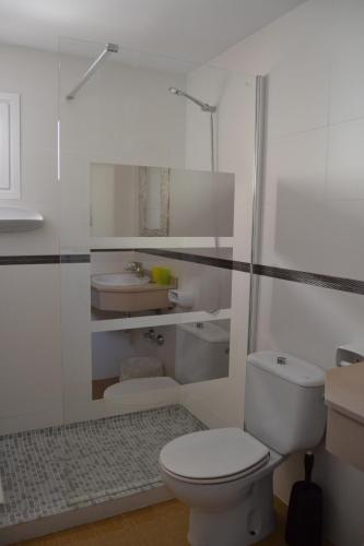 ein weißes Bad mit einem WC und einem Waschbecken in der Unterkunft Hotel Vista Sol in Cala Ratjada