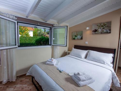 ein Schlafzimmer mit einem großen Bett mit Handtüchern darauf in der Unterkunft Natalie Apartments in Artemida