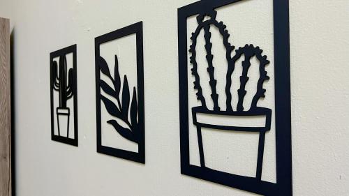 three framed pictures of a potted plant on a wall at Mahkota Aman Guest House - 5pax in Kuantan