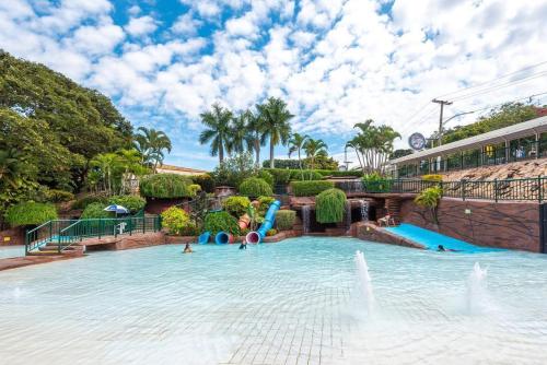 una gran piscina con un tobogán de agua en Hotel Villas diRoma com um dia de acesso no diRoma Acqua Park,, en Caldas Novas
