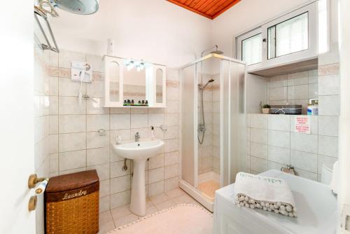 a bathroom with a sink and a tub and a toilet at Nina Apartment in Gaios