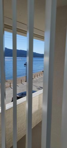 a view of a beach from a window at By The Sea - Paleros in Paleros