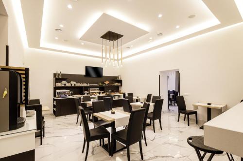 um restaurante com cadeiras e mesas pretas e um balcão em Best Western Hotel dei Mille em Nápoles