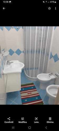 uma casa de banho com um lavatório e um WC em Monolocale em Palinuro