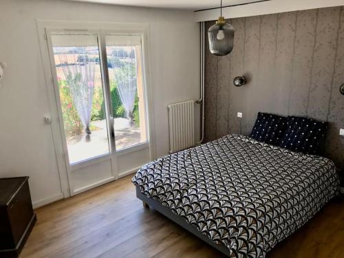 a bedroom with a bed and a large window at On dirait le sud ! Guesthouse centre ville et vue. in Thouars