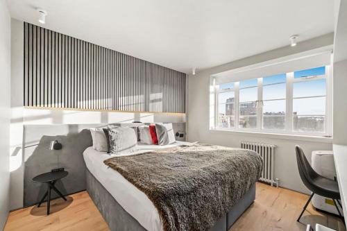 a bedroom with a large bed and a large window at Two Bedroom Flat in Kensington in London