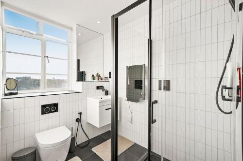 ロンドンにあるTwo Bedroom Flat in Kensingtonの白いバスルーム(シャワー、トイレ付)
