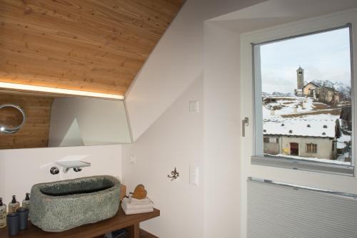 La salle de bains est pourvue d'un lavabo et d'une fenêtre. dans l'établissement Boutique Hotel Locanda Fior di Campo, à Campo