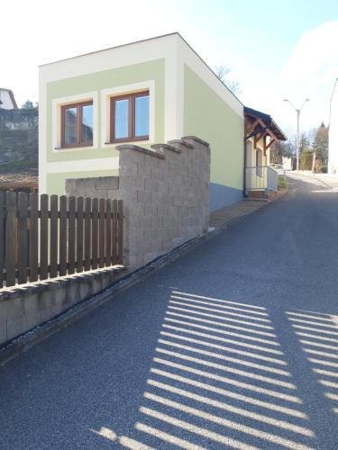 a house with a fence on the side of a street at Apartmán Plasy in Plasy