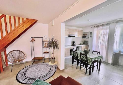 a living room with a table and a kitchen at Jolie maison 2 chambres - CLIM MOBILE - TV - Proche d un lac in Ruelle-sur-Touvre