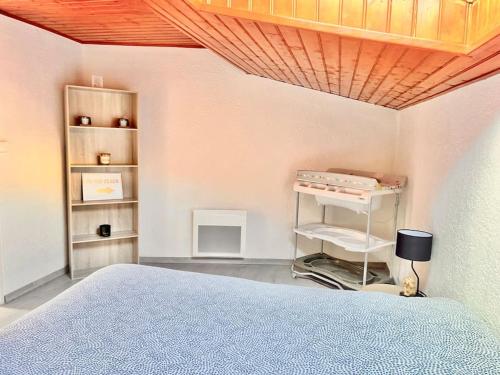 a bedroom with a bed and a wooden ceiling at Jolie maison 2 chambres - CLIM MOBILE - TV - Proche d un lac in Ruelle-sur-Touvre