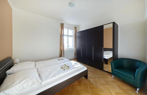 um quarto com uma cama e uma cadeira azul em Hostel Foster em Mariánské Lázně