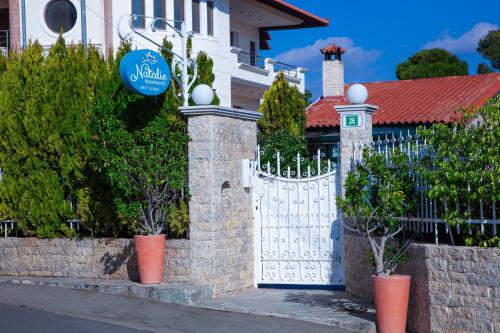 a white gate in front of a house at Natalie Apartments in Artemida