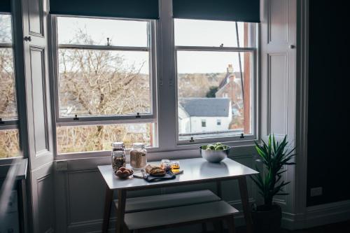 a table in front of two windows with food on it at The Main Street Burrow - Your Perfect Hideaway in Saint Boswells