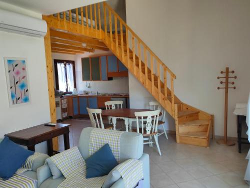 uma sala de estar com uma escada e uma mesa em Villa Cala Sinzias em Castiadas