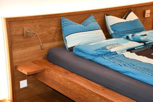 a bed with blue and white pillows on it at Hof-Fankhauser in Wasen