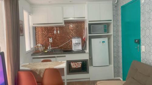 a kitchen with a table and a refrigerator in it at Studio expo norte Bras SP feira da madrugada in Sao Paulo