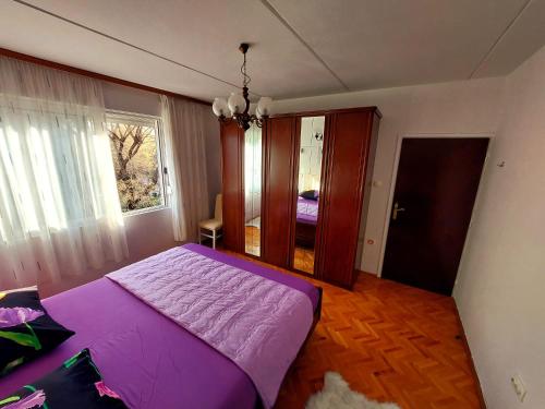 a purple bed in a room with a window at Split apartment in Split