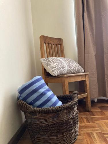 a chair and a pillow in a basket next to a chair at Departamento acogedor en la mejor zona de La Paz in La Paz