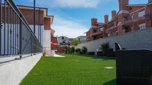 a yard with green grass next to some buildings at RobHouse in Passo Corese
